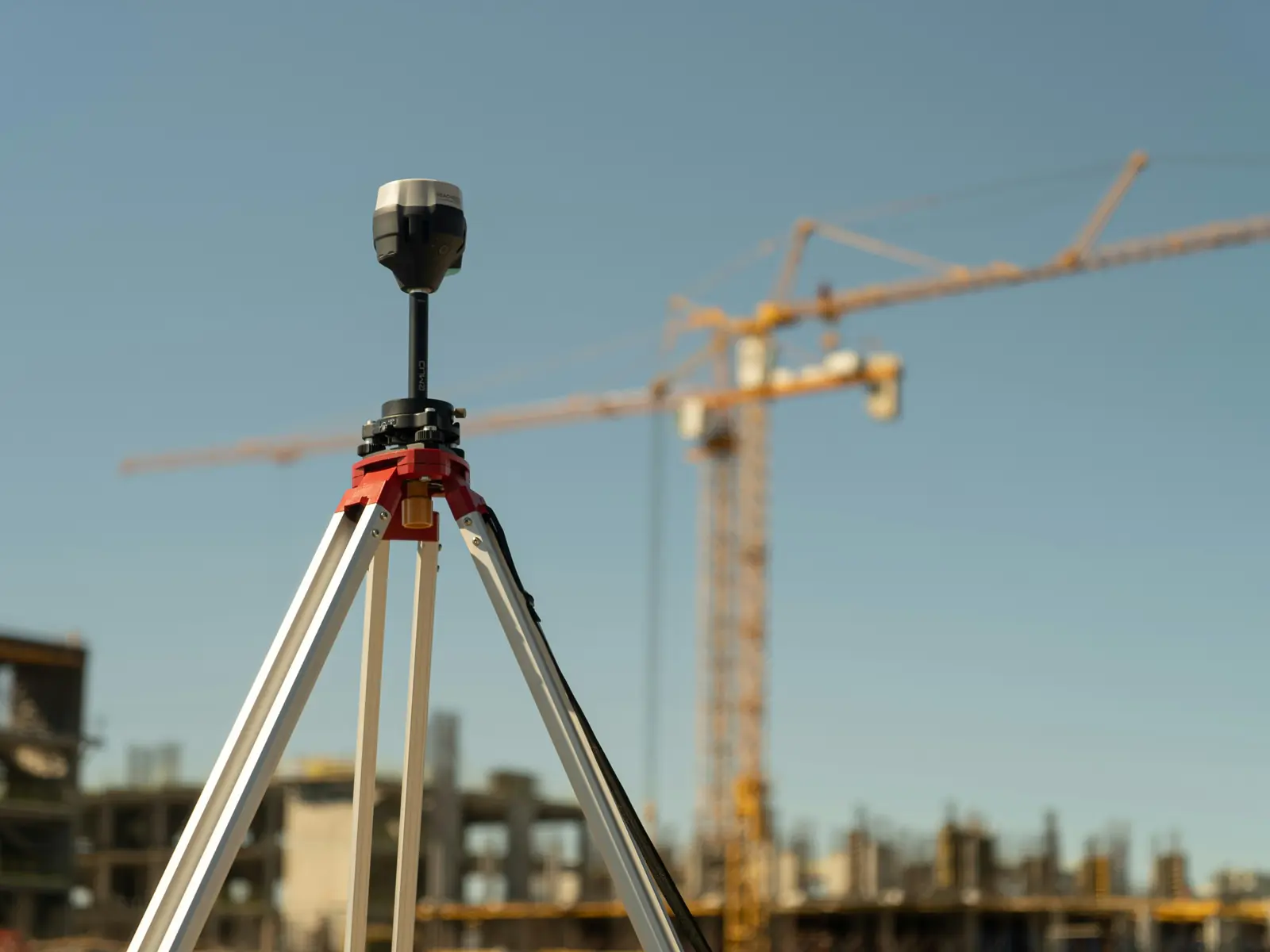 GNSS antena na stativu, u pozadini građevinska dizalica